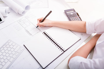 Close up hands of construction engineer working with the tool on project drawings background at...