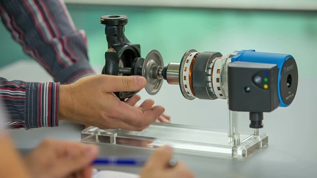 A man is explaining to another man how the device in front of him works. They are testing ti out together. 