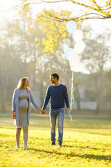 Young couple expecting baby and have fun in the park