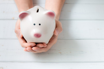 Piggy bank protected by hands