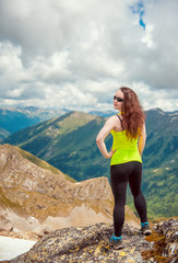 Woman hiker standing on the top of mountain