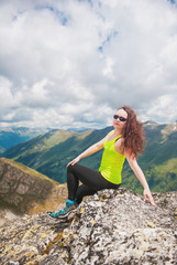 Woman hiker sitting on the top of mountain