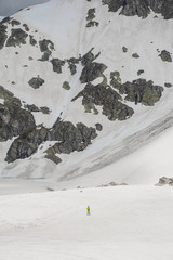 Small figure of man on the big space of glacier snow