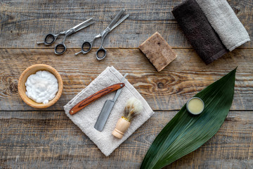 Barber workplace. Shaving brush, razor, foam, sciccors on wooden table background top view