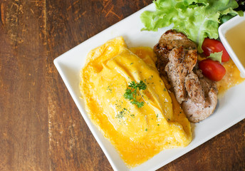 omelete rice with roasted pork on wood table