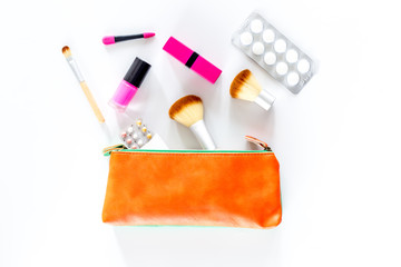 Beauty bag with cosmetics, contraceptives and pills on white table background top view copyspace