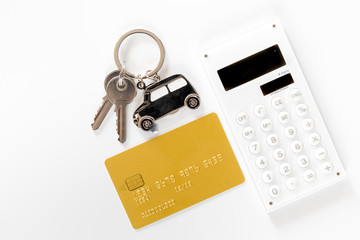 Buying car. Car keys and bank card on white background top view copyspace