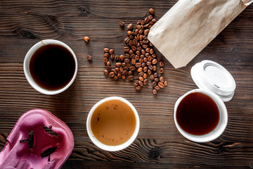 Coffee take away. Coffee cups with covers and coffee beans on wooden table backound top view