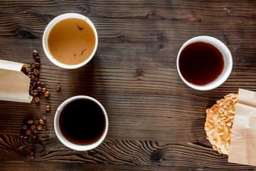 Coffee take out. Coffee cups with covers, coffee beans and cookies on wooden table backound top view copyspace