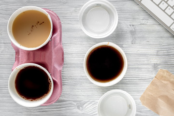 Coffee to go. Coffee cups with cover on wooden table backound top view