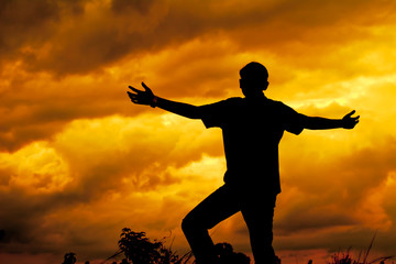 Fototapeta na wymiar Silhouette man praying with hand up to God. Sunset background.
