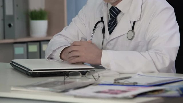 Weary male doctor thinking about medical cases that occurred in his practice