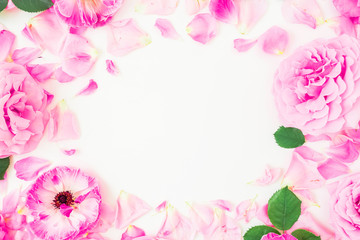 Round frame made of pink flowers, petals and leaves on white background. Floral lifestyle composition. Flat lay, top view.