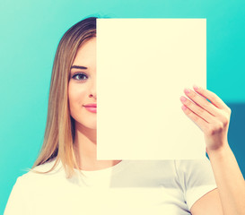 Woman holding a blank sheet of paper in front of her face