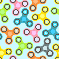 Nice colorful fidget spinners on light blue background seamless pattern. Fashionable texture with popular stress-relieving toys for textile, background, wrapping paper, covers, surface, design