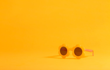 Sunflower shaped sunglasses on a yellow background