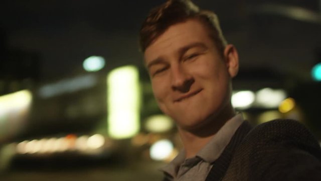 Young man is making funny moves in front of camera on a street
