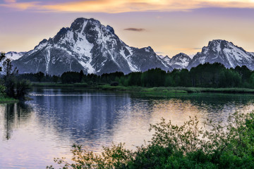 Snowy Mountain Peak Reflects on Lake at Sunset