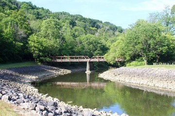 Fototapeta na wymiar The bridge at the park reflecting off the creek water.