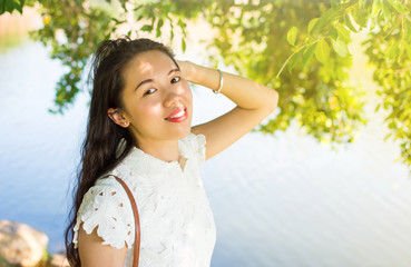 Girl standing by the lake and enjoying the summer breeze