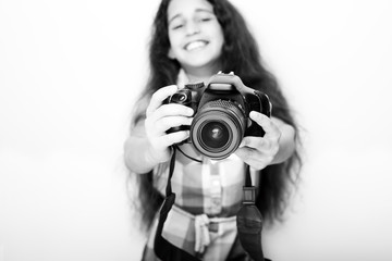 Cute brunette little girl holding an photo camera, isolated on white background