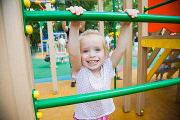 Fototapeta na wymiar Cute little girl on a colorful playground