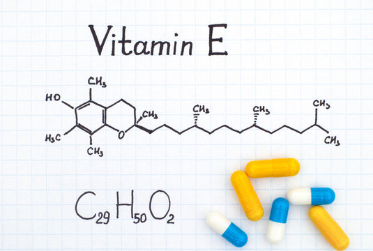 Chemical formula of Vitamin E and pills.