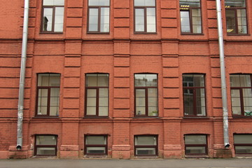 Fototapeta na wymiar Brick wall with windows and drainpipes
