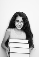 Adorable girl studying with eyeglasses and books in the hand on white background