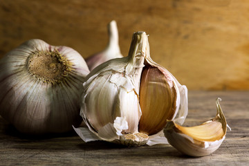 Garlic clove and garlic bulb on wooden background