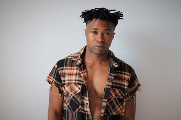 Posierender attraktiver schwarzer Mann mit offenem Hemd