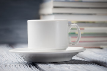 Cup of coffee over defocused pile of books
