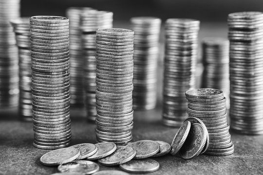 Black and white picture of coins stacks, shallow depth of field.