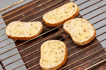 Seed bread slices with melted butter on the grill