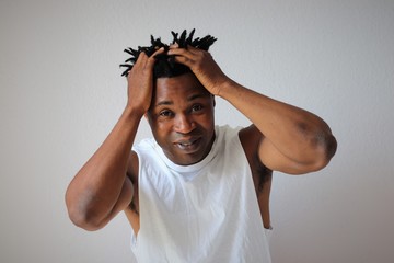Schwarzer afrikanischer Mann fässt sich mit beiden Händen an den Kopf