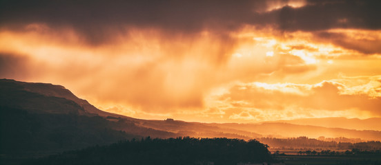 The last rays of the setting Sun magically lighting up a valley near Stirling. Stirlingshire, Scotland, UK
