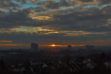 Bewölkter Sonnenuntergang über einer Stadt