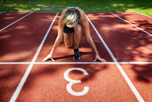 Sport backgrounds. Sprinter starting on the running track. Dramatic image.