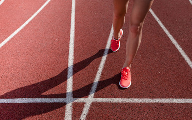 Red running track  with female runner, close up on shoes