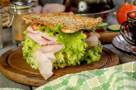Sandwich with ham, cucumber, tomato and lettuce.
