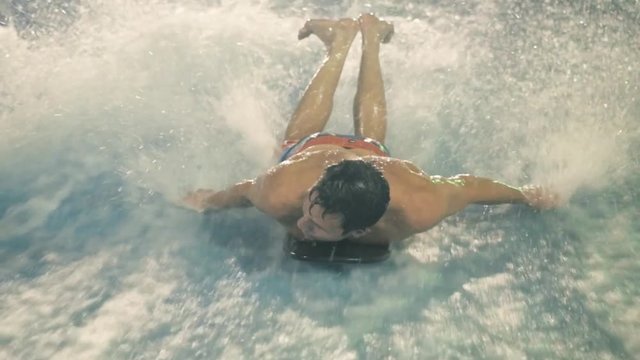 People practice surfing It's a aquapark, extreme athlete on shortboard, surfboard on wave attraction, happy sport people, close legs on board on vawe