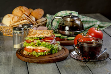 Sandwich with ham, cucumber, tomato and lettuce.