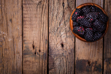 Blackberry Fresh in a wooden bowl.Berry on a wooden vintage background.Food or Healthy diet concept.Super Food.Vegetarian.Top View.Copy space for Text.selective focus.