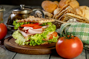 Sandwich with ham, cucumber, tomato and lettuce.