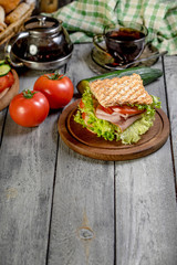 Sandwich with ham, cucumber, tomato and lettuce.
