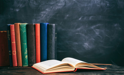 Vintage books on blackboard background