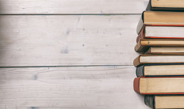 Vintage books stack on wooden background - copy space