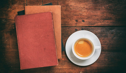 Obraz na płótnie Canvas Vintage books and a cup of coffee on wooden background