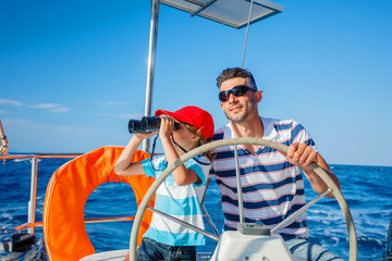 Young man with his son sailing yacht