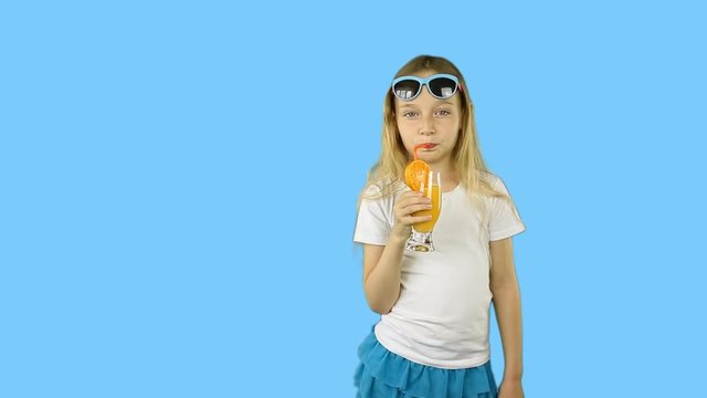Joyful young girl drinking orange juice from glass and stroking belly. Happy girl drink orange cocktail through straw. Clip with Premultiplied matted Alpha Channel. Transparent BG PNG.